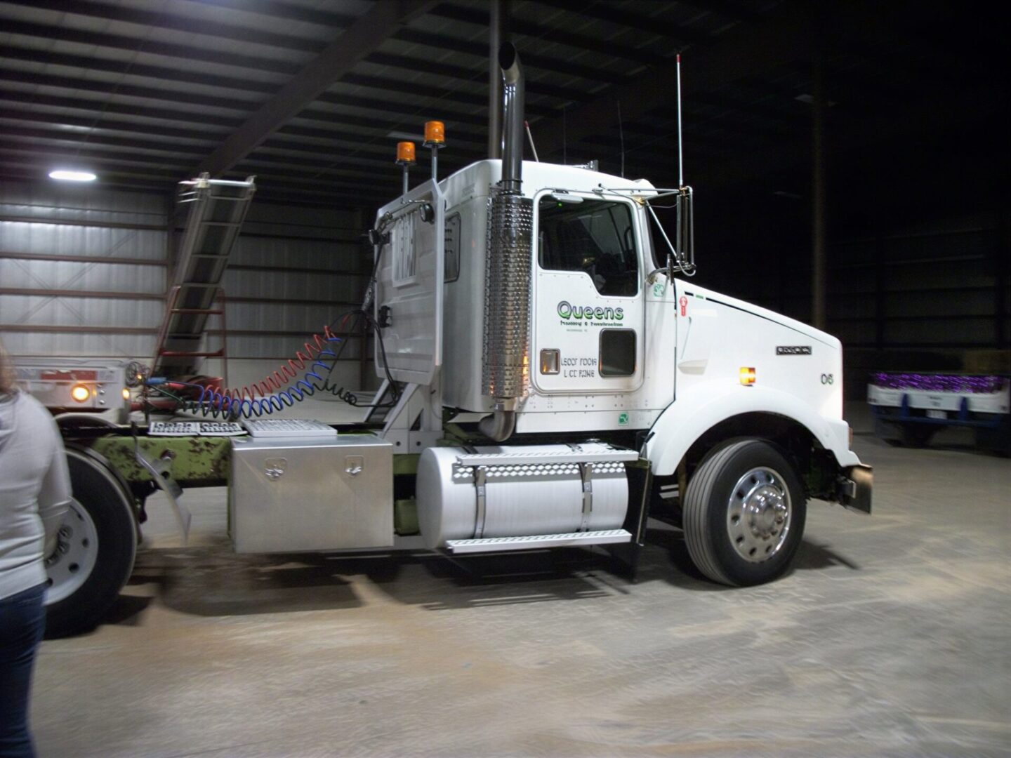 White semi-truck parked inside dim warehouse