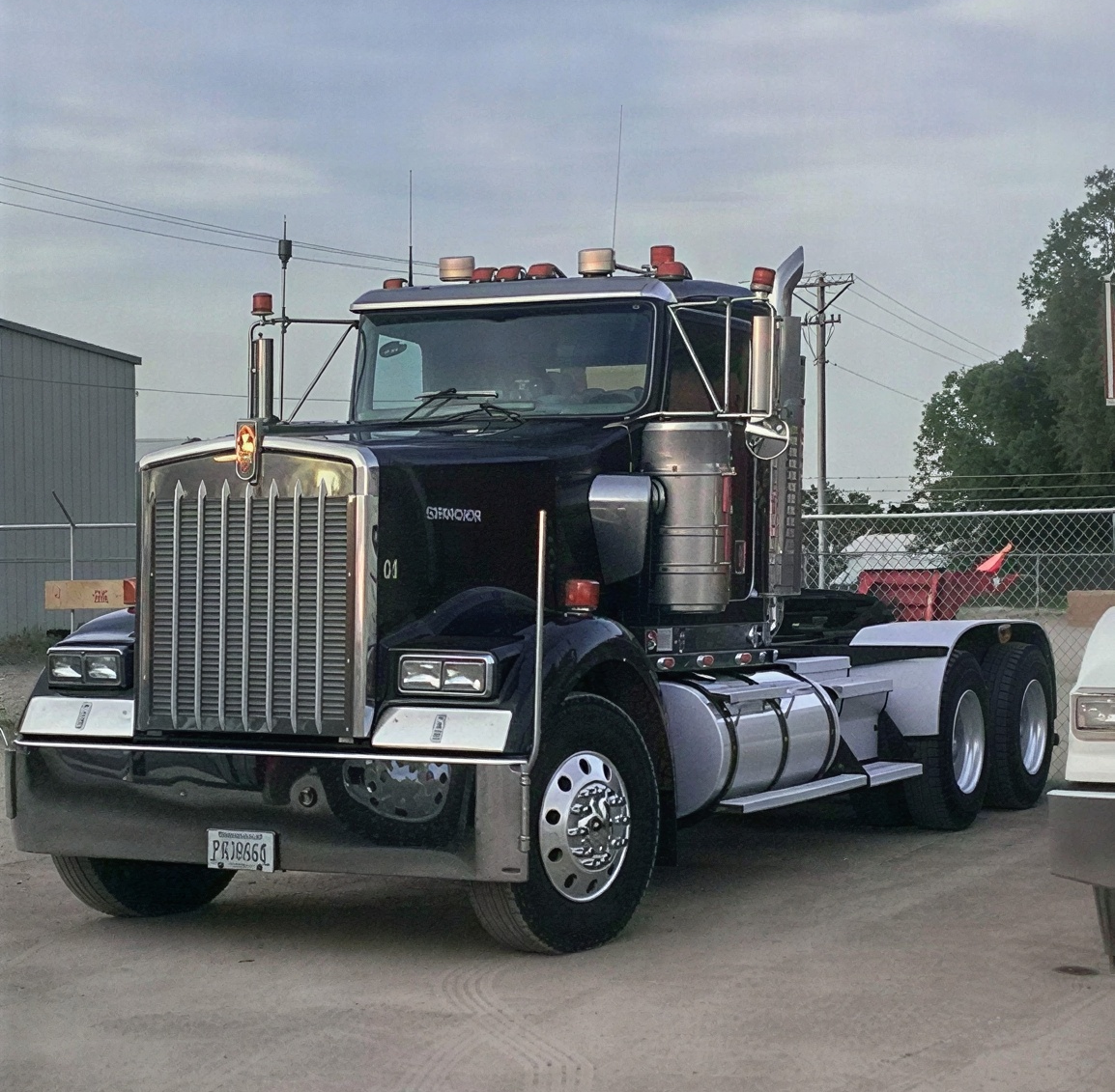 Black semi truck parked in gravel lot