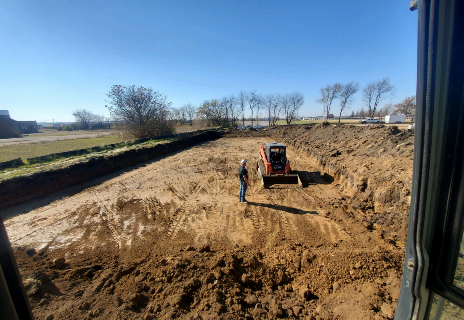 Excavator digging large pit on sunny day