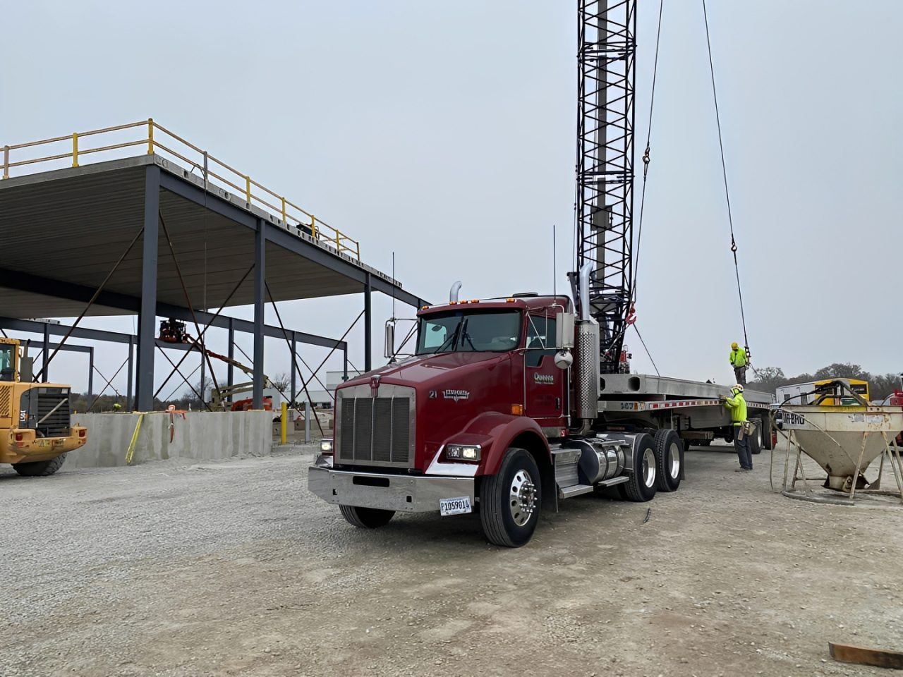 Workers operating crane near building framework