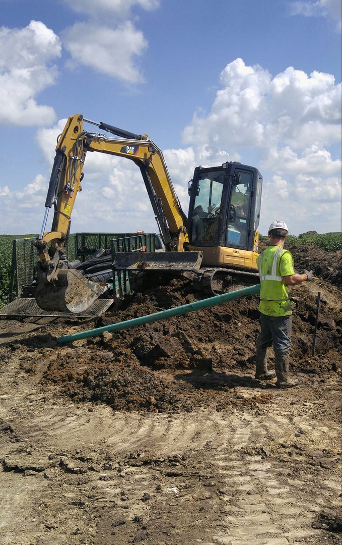 Worker managing excavation with machinery nearby