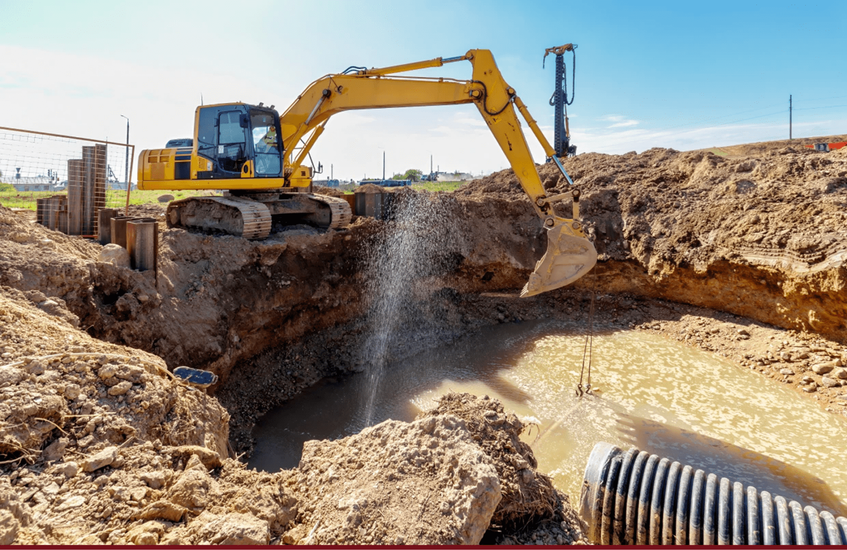 Yellow excavator digging muddy construction pit